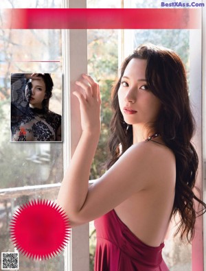 A woman with long brown hair and a pink flower in her hair.