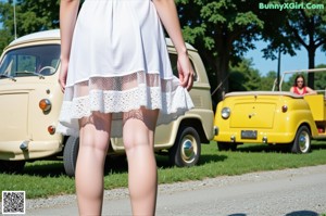 A woman in a white dress is posing for a picture.
