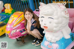 A woman in a school uniform is posing for a picture.