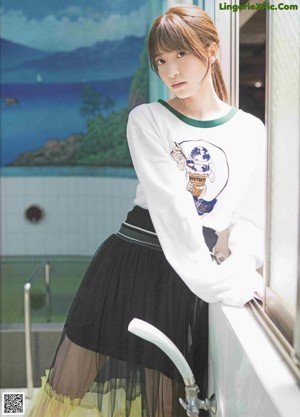 A woman with long brown hair and bangs is posing for a picture.
