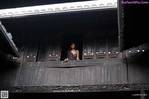 A naked woman sitting on a chair in a room.