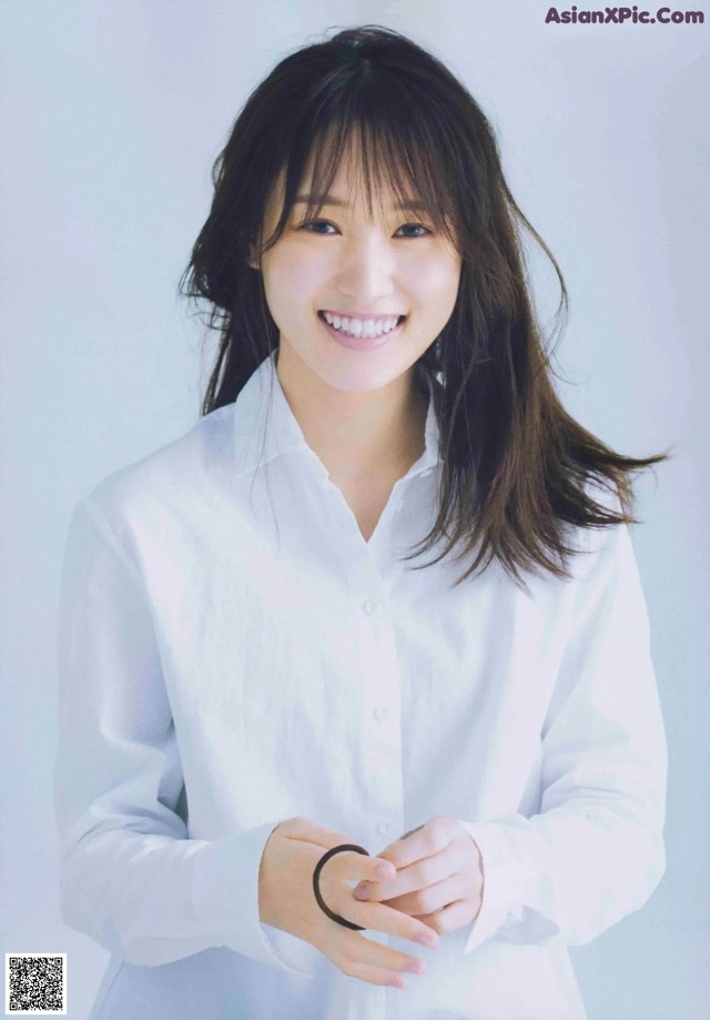A woman in a white shirt smiles at the camera.