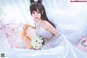 A woman in a wedding dress holding a bouquet of flowers.