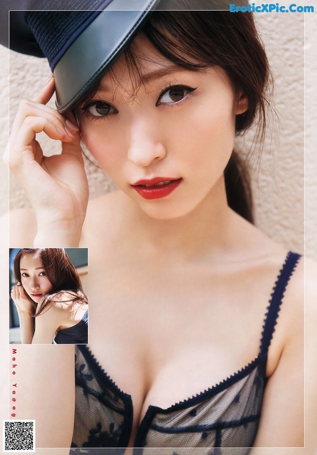 A woman wearing a black hat and a black bra.