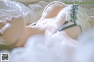 A woman in a yellow bra sitting on a bed.