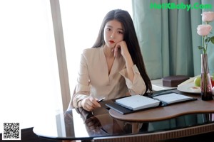A woman standing in front of a table in a room.