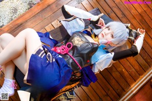 A woman sitting on a wooden bench holding a sword.