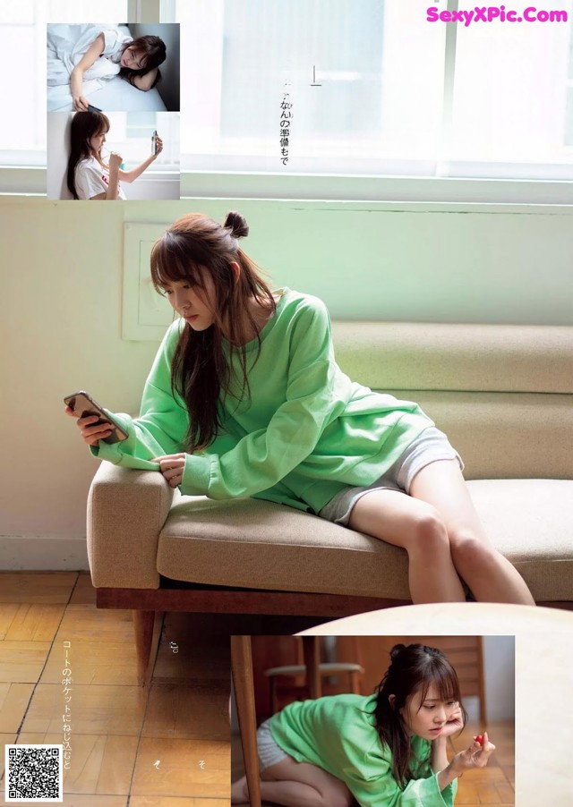 A woman sitting on a couch looking at her phone.