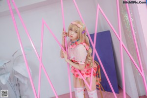 A woman in a pink and white outfit posing for a picture.