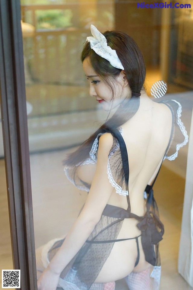 A woman in lingerie looking out of a window.