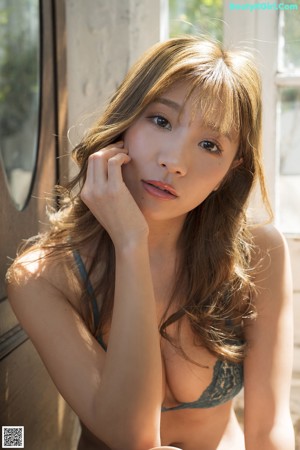 A woman in a black bathing suit sitting in a chair.