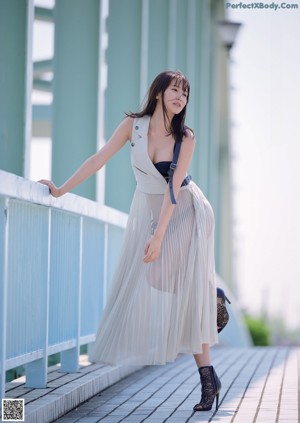 A woman in a black bra is posing for a magazine cover.