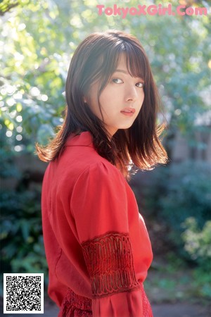 A woman wearing a white turtle neck sweater and a beige dress.