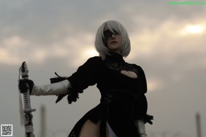 A woman in a black and white outfit holding a sword.