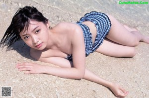 A woman in a school uniform leaning on the edge of a swimming pool.