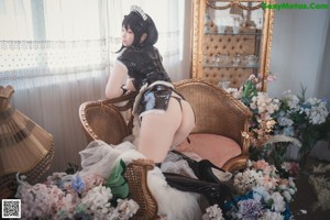 A woman in a black and white lingerie sitting on a chair.