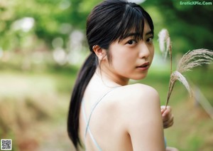A woman laying on a tatami mat in a blue bikini.
