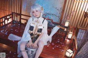 A woman in lingerie sitting on a wooden floor.