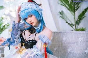A woman in a blue and white dress posing for a picture.