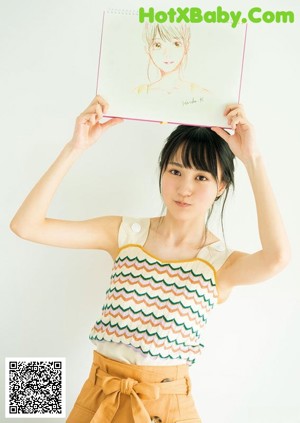 A woman in a long pink dress posing for a magazine.