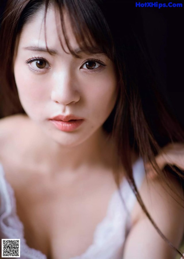 A woman in a white dress posing for a picture.