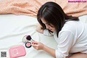 A woman laying on a bed next to a brush.