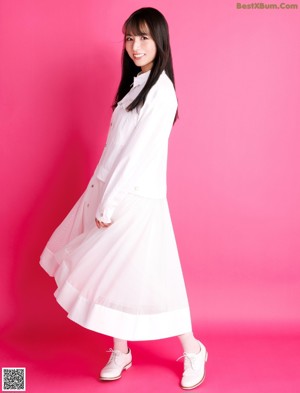 A woman in a white shirt is posing for a magazine.