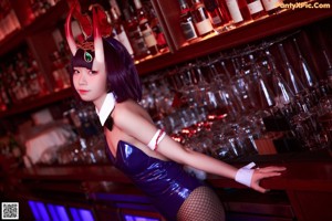 A woman dressed as a bunny holding a glass of wine.