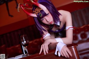 A woman sitting in a chair in front of a bar.