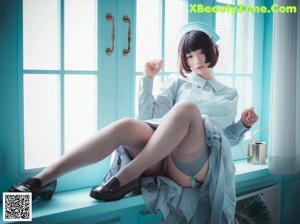 A woman in a nurse outfit sitting on a window sill.